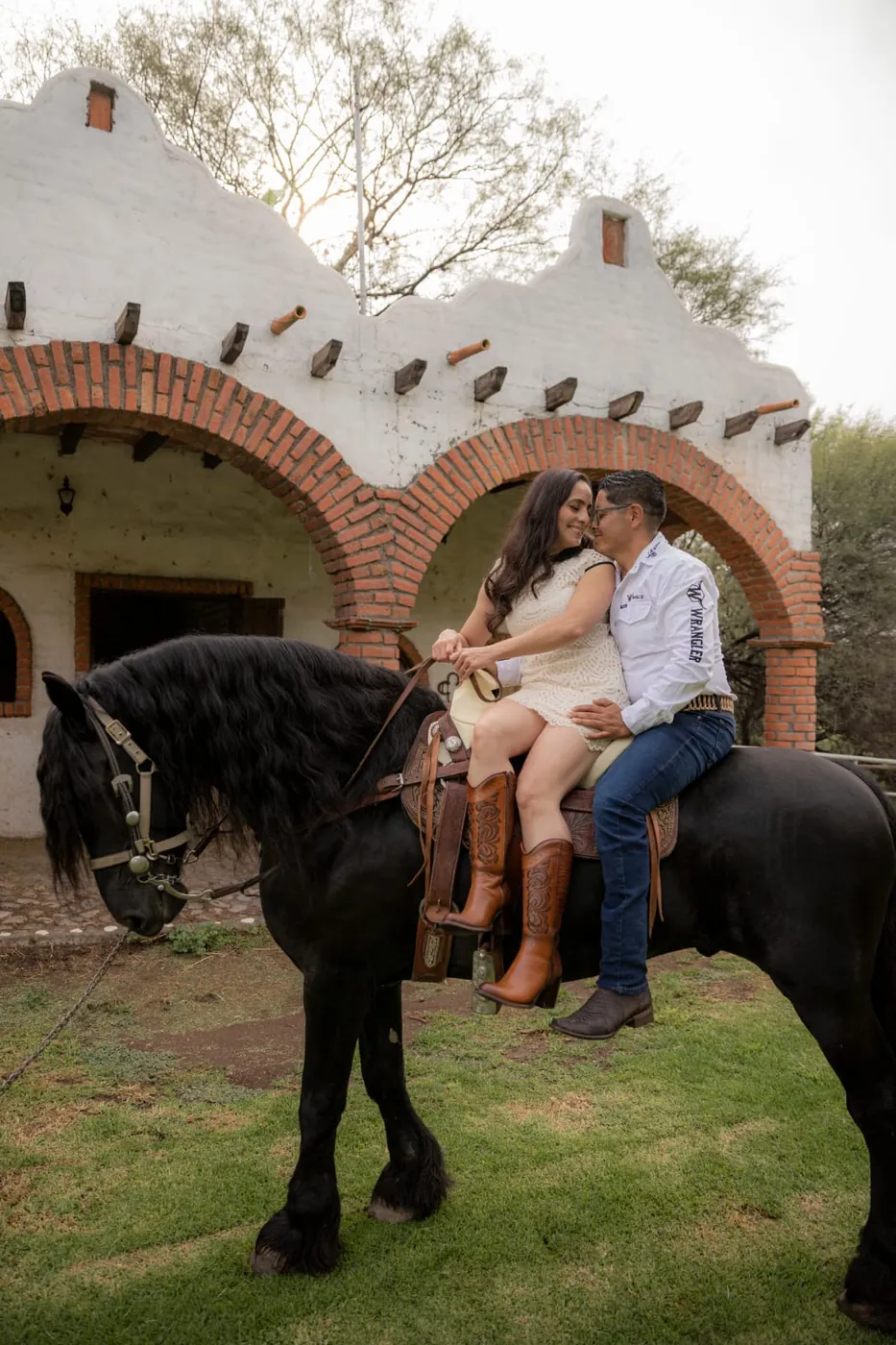 Mónica y Fernando a caballo frente a los arcos